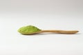 Closed up isolate heap of extract Green Tea powder in wooden sp
