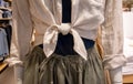 Closed up a knot tie of linen shirt at waist on mannequin. Fashionable outfit