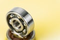 Closed up macro, Pouring automotive engine oil into ball bearing isolated on yellow oil background with copy space, engineering Royalty Free Stock Photo