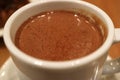 Closed up mouthwatering hot chocolate in a white cup with selective focus and blurred background