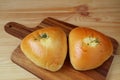 Closed up a pair of savory buns on wooden tray served on wooden table
