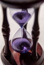 Closed up of sandglass or hourglass with violet, purple sand