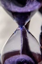 Closed up of sandglass or hourglass with violet, purple sand