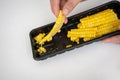 Closed up slimy string of spoiled corn in black plastic container kept too long in fridge. Royalty Free Stock Photo