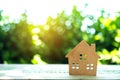 Closed up tiny home model on floor or wood board with sunlight green bokeh background. House property for living or investment Royalty Free Stock Photo