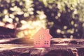 Closed up tiny home model on floor or wood board with sunlight green bokeh background. House property for living or investment Royalty Free Stock Photo