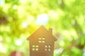 Closed up tiny home model on floor or wood board with sunlight green bokeh background. House property for living or investment Royalty Free Stock Photo