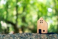 Closed up tiny home model on floor or wood board with sunlight green bokeh background. Deam life have own house property for Royalty Free Stock Photo