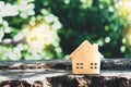 Closed up tiny home model on floor or wood board with sunlight green bokeh background. House property for living or investment Royalty Free Stock Photo