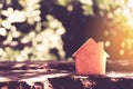 Closed up tiny home model on floor or wood board with sunlight green bokeh background. House property for living or investment Royalty Free Stock Photo