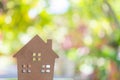 Closed up tiny home model on floor or wood board with sunlight green bokeh background. House property for living or investment Royalty Free Stock Photo