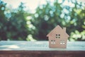 Closed up tiny home model on floor or wood board with sunlight green bokeh background. House property for living or investment Royalty Free Stock Photo