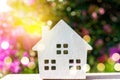 Closed up tiny home model on floor or wood board with sunlight green bokeh background. House property for living or investment Royalty Free Stock Photo