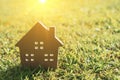 Closed up tiny home model on green grass with sunlight.