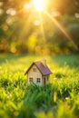 Closed up tiny home model on green grass with sunlight background Royalty Free Stock Photo