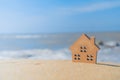 Closed up tiny home models on sand with sunlight and beach Royalty Free Stock Photo