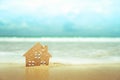 Closed up tiny home models on sand with sunlight and beach Royalty Free Stock Photo