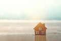 Closed up tiny home models on sand with sunlight and beach Royalty Free Stock Photo