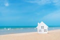 Closed up tiny home models on sand with sunlight and beach Royalty Free Stock Photo