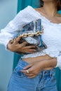 Closed up of trendy woman outfit with leather bag wearing white shirt and jeans. Royalty Free Stock Photo