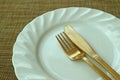 Closed Up White Ceramic Plate and Brass Cutlery on Beige Luncheon Mat Royalty Free Stock Photo