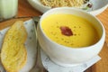 Yellow pumpkin soup with garlic bread serving on the timber block