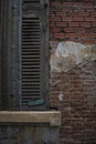 Closed Venetian blinds on a weathered bricks wall