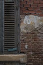 Closed Venetian blinds on a weathered bricks wall