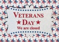 Closed Veterans Day sign with flag on wood