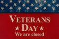 Closed Veterans Day sign with stars on red wood