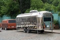 Retro style futuristic silver metal trailer van standing on summer day for fair, festival or event.