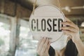 Closed, waitress woman wearing protection face mask turning open sign board on glass door in modern cafe coffee shop Royalty Free Stock Photo