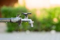 Closed water faucet or tap in blur green garden background