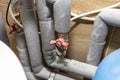 Closed water valves for equalizing the water pressure in a gas boiler in a modern home boiler room with ceramic tiles.