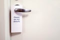 Closed door of hotel room with please do not disturb sign Royalty Free Stock Photo