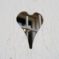 closed white shutter with a heart-shaped opening and cracks in the paint Royalty Free Stock Photo