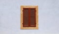 Closed window with brown shutters on blue ancient wall Royalty Free Stock Photo