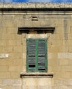 Window of the old building covered by green wooden blinds in Rabat town on Malta Royalty Free Stock Photo