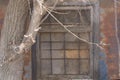 Closed window on old building with iron bars. Rust and peeling paint on walls of facade Royalty Free Stock Photo