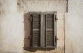 Closed window with shutters on ancient wall, soft filter. Facade of old abandoned house, toned. Window with wooden shutters. Royalty Free Stock Photo