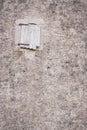 Closed window with wooden shutters on cement wall. Abandoned medieval building. Facade of ancient house. Exterior of old building. Royalty Free Stock Photo