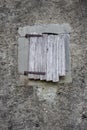 Closed window with wooden shutters on cement wall. Abandoned medieval building. Facade of ancient house. Exterior of old building. Royalty Free Stock Photo