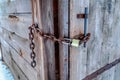 Closed wood door of outdoor bathrooom with rusty chain and long shackle padlock Royalty Free Stock Photo