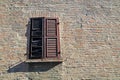 Closed wood window on aged brick wall background.