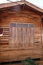 Closed wood window of old wooden house wall.