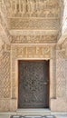 Closed wooden aged door with ornate bronzed floral patterns