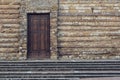 Closed wooden door on ancient stone wall facade Royalty Free Stock Photo