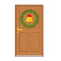 Closed wooden door and Christmas holly berry wreath round frame with gold bell and red bow Royalty Free Stock Photo