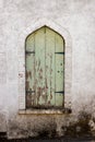 Closed wooden green shuttered arched window