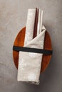 Closed wooden Japanese lunchbox with chopsticks, wrapped in a festive cloth on an old stone table. Top view